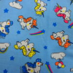 MULTI COLOURED UNICORNS ON SKY BLUE BACKGROUND